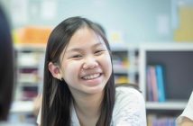 Cheerful young Asian girl enjoying English tuition in Singapore